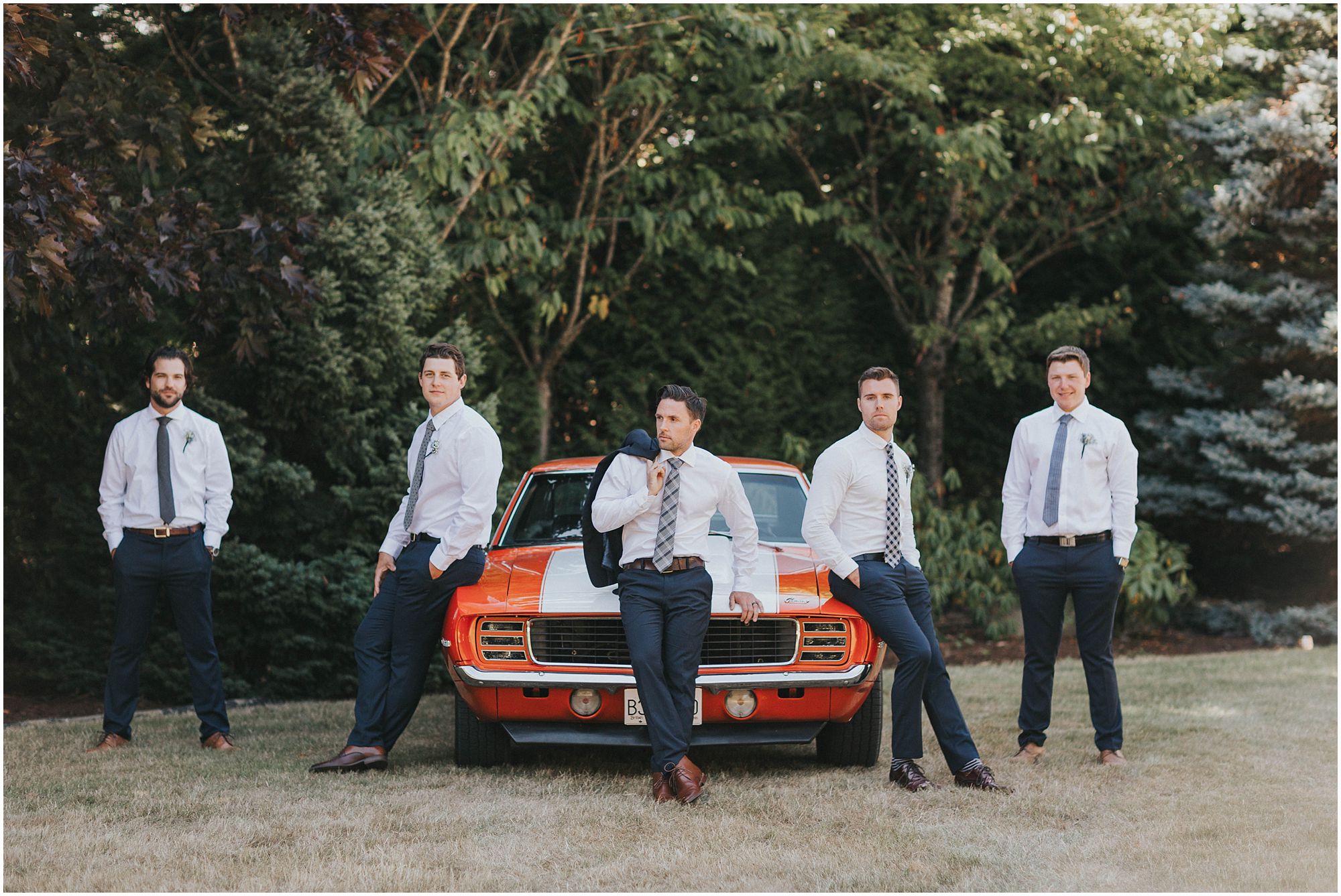 handsome groomsmen posing with old classic mustang 