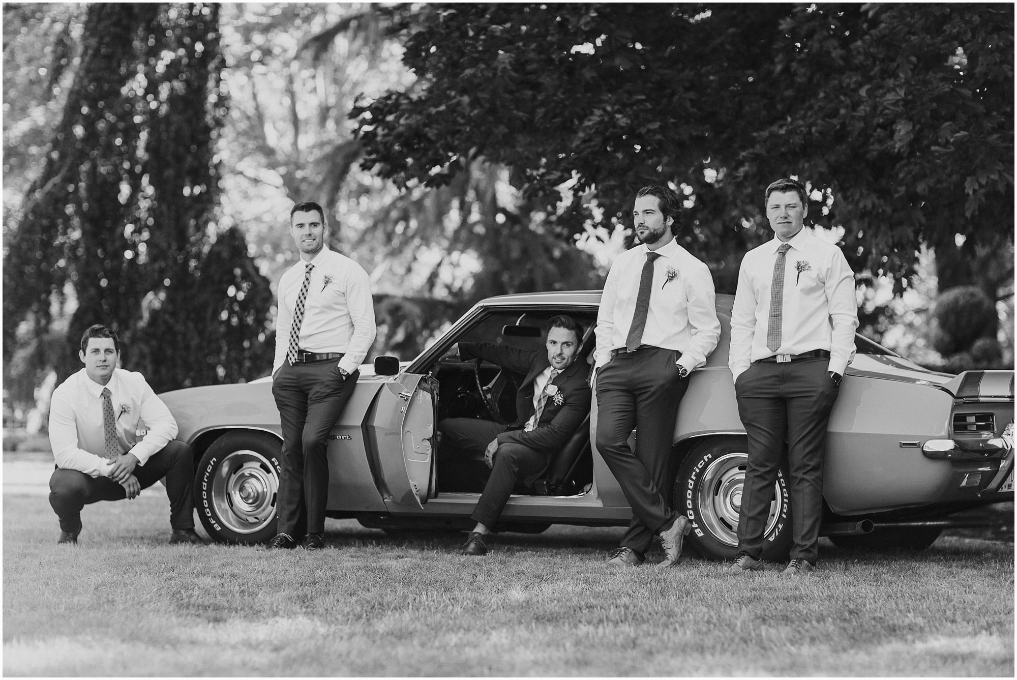 handsome groomsmen posing with old classic mustang 