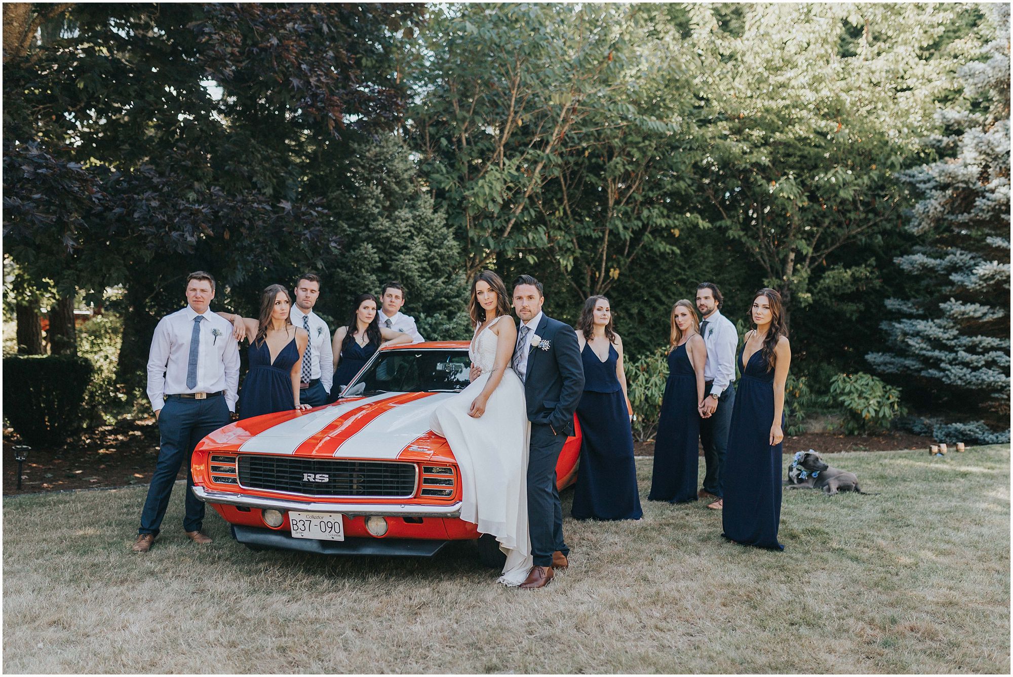 beautiful bridal party posing with old classic mustang 