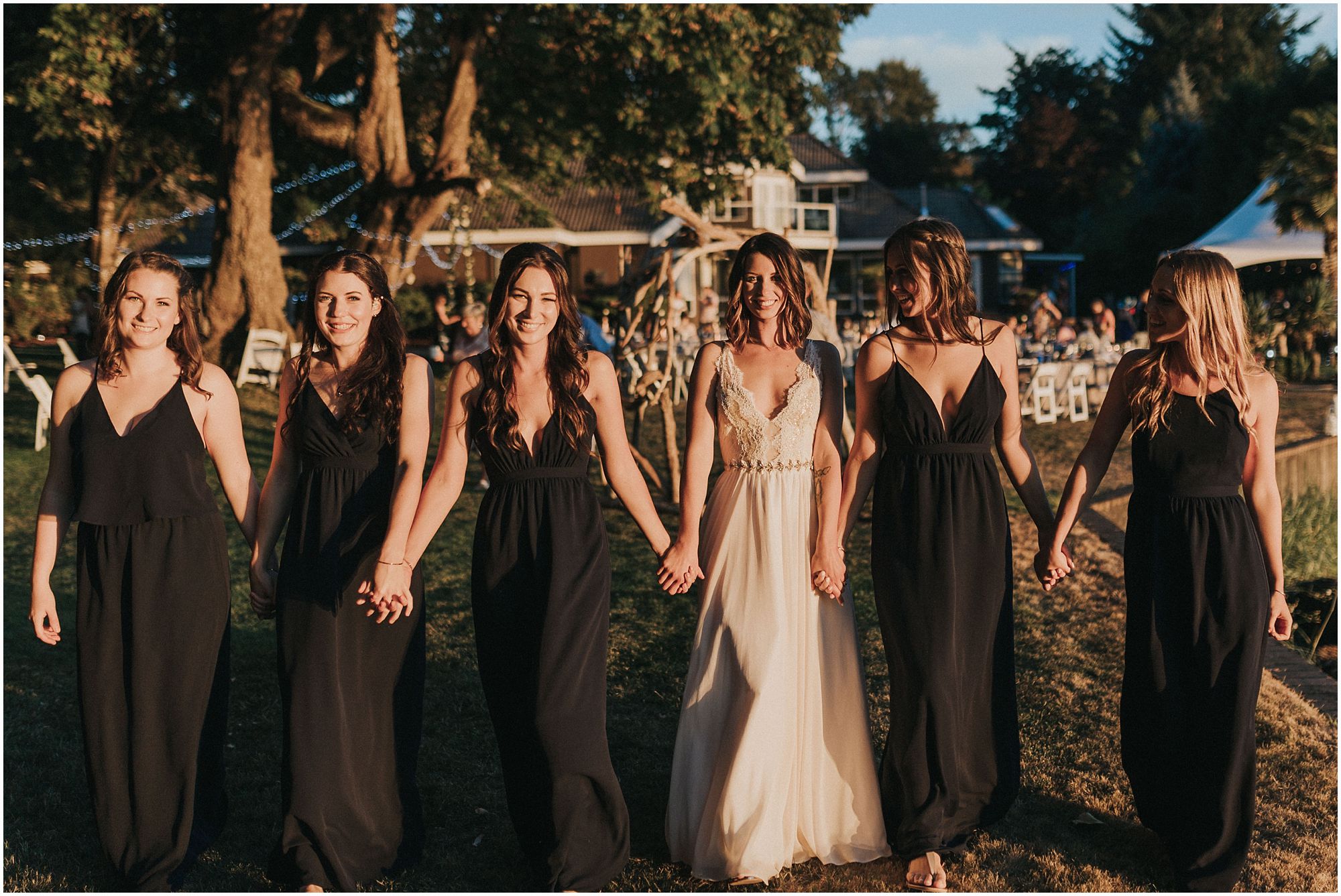 bride and her bridesmaids walking into the sunset